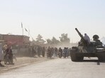 An Afghan Taliban fighter sits on a tank near the Afghanistan-Pakistan border in Spin Boldak
