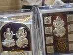 This year, silver coins printed with images of Laxmi, Ganesh and Saraswati, packed carefully with essential items for puja like roli, rice and kalewa, dhoop and havan cups, silver-embedded photo frames, vastu items like shree charan and shree yantra are widely available in the market. (HT)