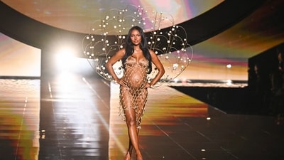 Jasmine Tookes, nine months pregnant, cradled her baby bump while opening the 2025 Victoria’s Secret Fashion Show in a sheer, netted dress with dramatic wings at the back. (Evan Agostini/Invision/AP)