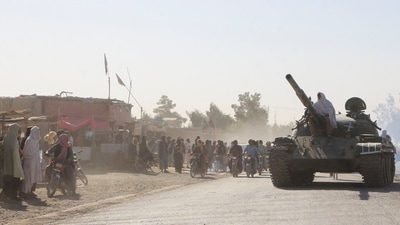 An Afghan Taliban fighter sits on a tank near the Afghanistan-Pakistan border in Spin Boldak (REUTERS)