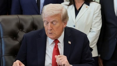 President Donald Trump looks at a folder on his desk during an event in the Oval Office at the White House in Washington, D.C. (REUTERS)