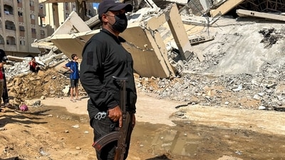 Hamas militant stands guard near a site where searches are underway (REUTERS)