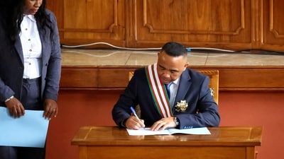 Madagascar's new military ruler, Colonel Michael Randrianirina, signs documents after being sworn in as president on Friday. (Reuters)