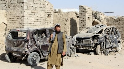 A Taliban fighter stands next to vehicles destroyed during an airstrike amid the conflict between Afghanistan and Pakistan, in Spin Boldak district of Kandahar Province, Afghanistan. (REUTERS)