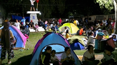 Residents gather at a park amidst a tsunami warning after a 6.7 aftershock hits Davao Oriental province, in Mindanao early evening on October 10, 2025. (AFP)