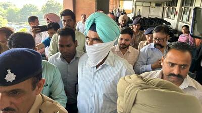 Punjab Police deputy inspector general Harcharan Singh Bhullar being escorted out of the court in Sector 43, Chandigarh, on Friday. (Keshav Singh/HT)