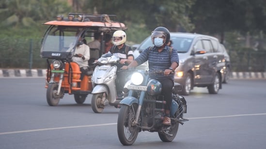 People are seen wearing face masks due to the rising air pollution at Sector-29 Road near Signature Tower, in Gurugram, ahead of Diwali.(Parveen Kumar/Hindustan Times)