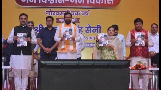 Haryana chief minister Nayab Singh Saini releasing a coffee table book during the state-level function that was held to mark the completion of one year of the BJP government in the state on Friday. (Sant Arora/Hindustan Times)