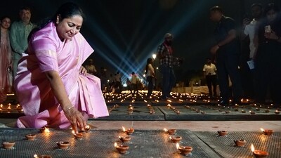 Delhi Chief Minister Rekha Gupta lights an earthen lamp during the Deep Mahotsav celebrations, at Kartavya Path in New Delhi on Saturday. (ANI Photo/Atul Kumar Yadav) (Atul Kumar Yadav)