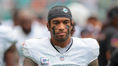 Miami Dolphins quarterback Tua Tagovailoa (1) walks by the bench area. (IMAGN IMAGES via Reuters Connect)