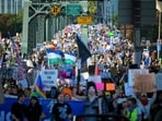 Demonstrators march over the Hawthorne Bridge during the "No Kings" protest on October 18, 2025 in Portland, Oregon.&nbsp;