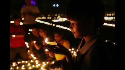 A boy carries a traditional earthen oil lamp on the eve of Diwali in Varanasi on October 19, 2025. (AFP)