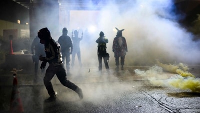 Anti ICE protestors clash with federal guards at US immigration and customs enforcement building on October 18 in Portland, Oregon. (Mathieu Lewis-Rolland/Getty Images via AFP)