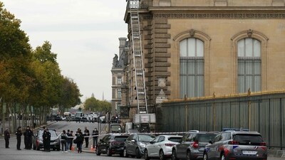French police officers stand next to a furniture elevator used by robbers to enter the Louvre museum. (AFP) French police officers stand next to a furniture elevator used by robbers to enter the Louvre museum. (AFP)