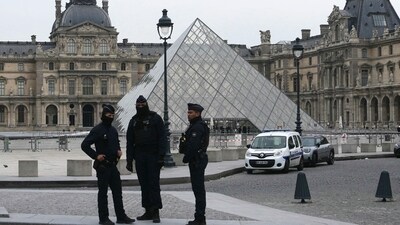 French police officers stand in front of the Louvre Museum after robbery, in Paris on October 19, 2025. (AFP)
