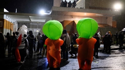 Anti ICE protestors stand in inflatable costumes near the US immigration building on October 18 in Porland as they protest against the federal government. (Mathieu Lewis-Rolland/Getty Images via AFP)