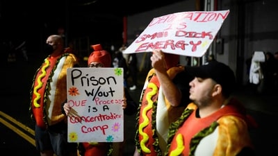 Anti ICE protestors wear costumes and hold signs near the U.S. Immigration and Customs Enforcement building on October 18, 2025 in Portland, Oregon as they protest against the Trump administration. (Mathieu Lewis-Rolland/Getty Images via AFP)