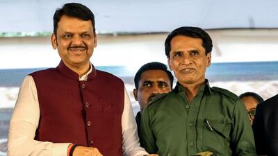 TOPSHOT - This handout photograph taken on October 15, 2025, and released by India's Maharashtra state Chief Minister's office shows the state Chief Minister Devendra Fadnavis (L) posing alongside senior Maoist rebel leader Mallojula Venugopal Rao, also known as "Sonu", as they hold an AK47 assault rifle during an event at Gadchiroli in Maharashtra, as the leader surrendered with around 60 fighters, after the guerrillas announced a halt to their decades-long insurgency. India is waging an intense campaign against the last remnants of the Naxalite rebellion, named after the village in the Himalayan foothills where the Maoist-inspired insurgency began nearly six decades ago. (Photo by India's Maharashtra state Chief Minister's office / AFP) / RESTRICTED TO EDITORIAL USE - MANDATORY CREDIT "AFP PHOTO / India's Maharashtra state Chief Minister's Office / - / HANDOUT / " - NO MARKETING NO ADVERTISING CAMPAIGNS - DISTRIBUTED AS A SERVICE TO CLIENTS (AFP)