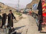 A tea vendor stands near the stalled vehicles near the closed Pakistan-Afghanistan border town of Torkham on October 19, 2025, after cross-border clashes between the two countries. Pakistan and Afghanistan agreed to an "immediate ceasefire" at talks in Doha, after at least 10 Afghans were killed in Pakistani air strikes that broke an earlier truce. (Photo by Basit GILANI / AFP)