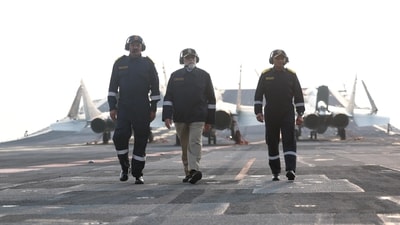 PM Modi walks into INS Vikrant with two naval officials as he reached the ship today to celebrate Diwali. (Sourced) PM Modi walks into INS Vikrant with two naval officials as he reached the ship today to celebrate Diwali. (Sourced)