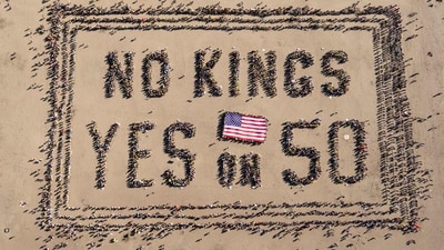 This aerial picture taken on October 18, 2025 shows protesters forming a human banner during the "No Kings" national day of protest on Ocean Beach in San Francisco, California. (AFP)