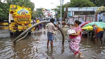 A worker unclogs drain on a waterlogged road following rains, in Chennai on Tuesday. (PTI) A worker unclogs drain on a waterlogged road following rains, in Chennai on Tuesday. (PTI)