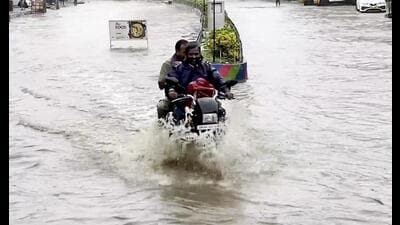 Commuters travel through a waterlogged road following heavy rain in Tirupati on Wednesday. (PTI PHOTO) Commuters travel through a waterlogged road following heavy rain in Tirupati on Wednesday. (PTI PHOTO)