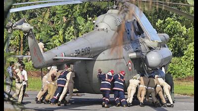 Police personnel try to push President Droupadi Murmu’s chopper after its wheels sank into the newly-built helipad at the Rajiv Gandhi Indoor Stadium in Pathanamthitta district. (PTI PHOTO) Police personnel try to push President Droupadi Murmu’s chopper after its wheels sank into the newly-built helipad at the Rajiv Gandhi Indoor Stadium in Pathanamthitta district. (PTI PHOTO)