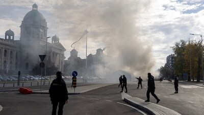 Police officers secure the area as smoke rises from a burning tent following an incident in front of the Parliament in Belgrade, Serbia, October 22, 2025. (REUTERS)