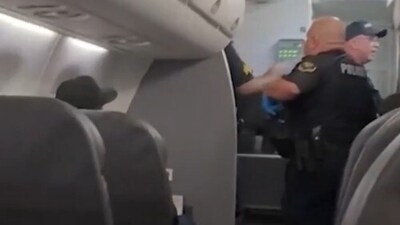 Officers boarded the plane after Flight 6469 made an emergency landing. (Grab from NY Post video) Officers boarded the plane after Flight 6469 made an emergency landing. (Grab from NY Post video)
