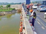 People dumping waste into the Sutlej River in Ludhiana on Thursday. (Gurpreet Singh/HT)