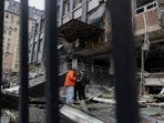 Residents stand near a damaged business centre following a drone attack in Kyiv, on October 23, 2025, amid the Russian invasion of Ukraine.