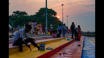 A worker paints a ghat on the banks of the Gomti river during sunset in Lucknow on Friday (PTI) A worker paints a ghat on the banks of the Gomti river during sunset in Lucknow on Friday (PTI)