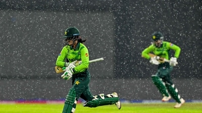 Pakistan's Muneeba Ali (L) and Omaima Sohail run towards the pavilion as rain stops play during the ICC Women's Cricket World Cup 2025 one-day international (ODI) match between Sri Lanka and Pakistan at the R. Premadasa International Cricket Stadium in Colombo on October 24, 2025. (Photo by Ishara S. KODIKARA / AFP) (AFP)