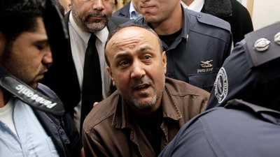 Jailed Fatah leader Marwan Barghouti (C) is accompanied by Israeli prison guards after a deliberation at Jerusalem Magistrate's court January 25, 2012. (REUTERS)