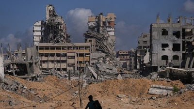 Palestinians walk through the destruction caused by the Israeli air and ground offensive in the Al-Shati camp, in Gaza City, Friday, Oct. 24, 2025. (AP Photo/Abdel Kareem Hana) (AP) Palestinians walk through the destruction caused by the Israeli air and ground offensive in the Al-Shati camp, in Gaza City, Friday, Oct. 24, 2025. (AP Photo/Abdel Kareem Hana) (AP)