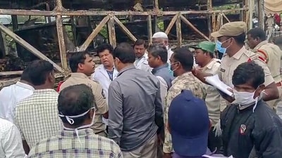 Police personnel and forensic team at the site of combusted bus tragedy after several people lose their lives as a bus burst into flames, near the Chinna Tekur village, in Kurnool on Friday. (ANI Video Grab)