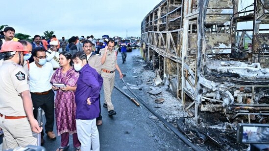 Kurnool District Collector A. Siri (in purple suit) speaks with police personnel at the spot after a Hyderabad-bound private bus caught fire in Kurnool district, Andhra Pradesh.(PTI)