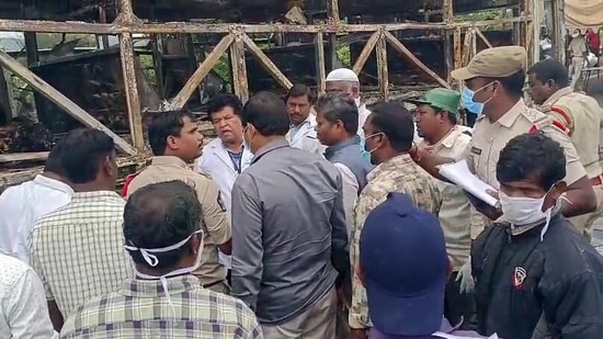 Police personnel and forensic team at the site of combusted bus tragedy after several people lose their lives as a bus burst into flames, near the Chinna Tekur village, in Kurnool on Friday.(ANI Video Grab)