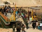 Alleged victims of scam centres board a boat to cross the river on the Myanmar-Thai border to be met by Thai Army soldiers as they are repatriated from Kyauk Khet in Myawaddy in Myanmar's Kayin State.