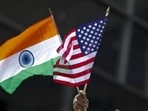 A man holds the flags of India and the US flag in New York.