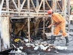 A member of the forensic team collecting samples from the spot after a bus caught fire following a collision with a two-wheeler in Kurnool on Friday. 