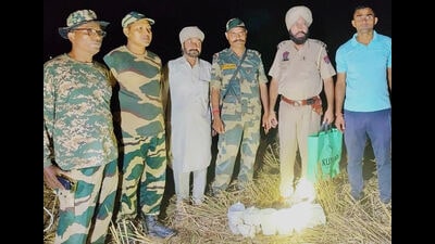 Security personnel with the contraband recovered from a field at Jalloke village in Ferozepur district on Saturday. (HT Photo)