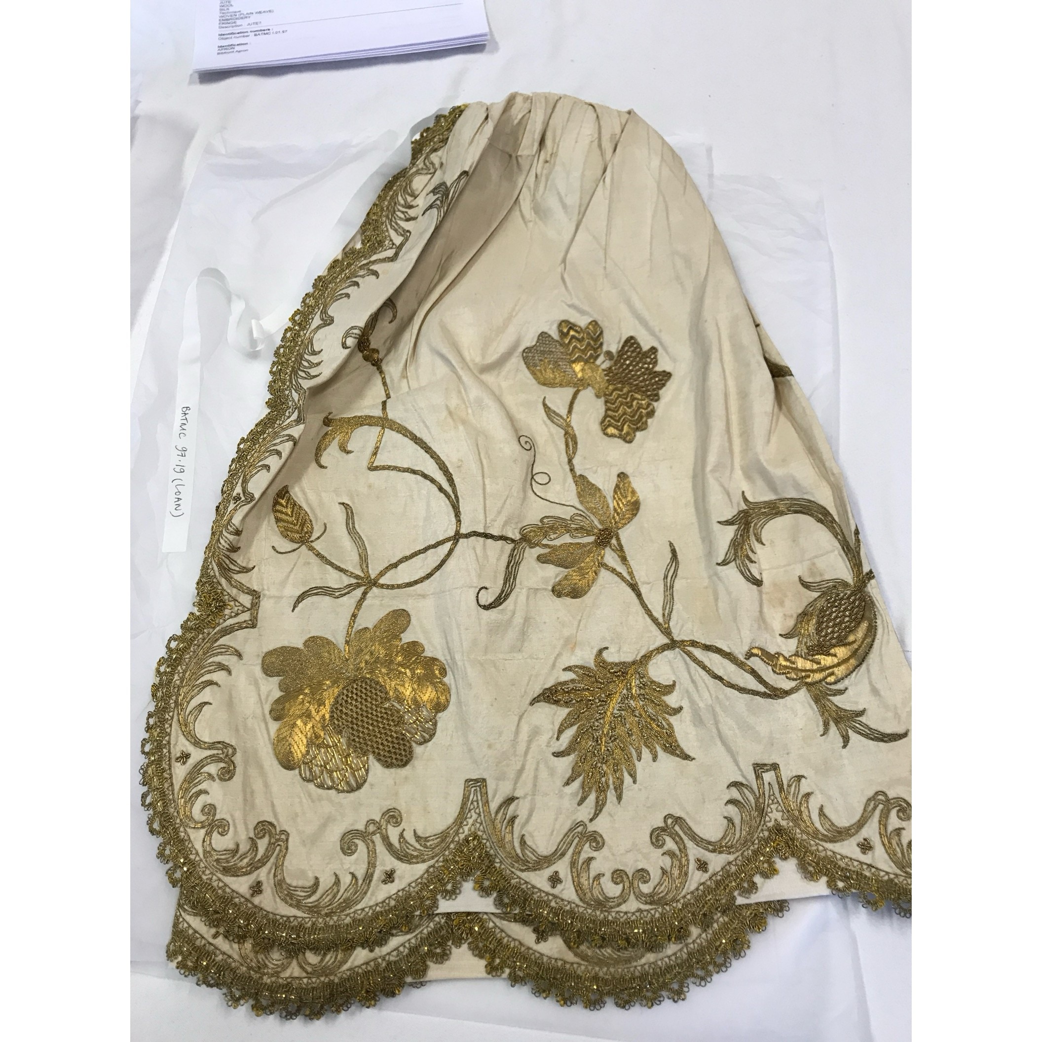 An apron featuring decorative gold embroidery, from the collection of Fashion Museum Bath. (Judith Clark) An apron featuring decorative gold embroidery, from the collection of Fashion Museum Bath. (Judith Clark)