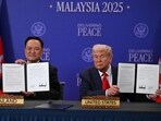 US President Donald Trump holds up a document with Thailand's Prime Minister during a ceremonial signing of a ceasefire agreement between Cambodia and Thailand.