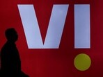 A man walks past a LED display board showing the logo of Vodafone-Idea in New Delhi. (REUTERS)