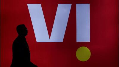A man walks past a LED display board showing the logo of Vodafone-Idea in New Delhi. (REUTERS) A man walks past a LED display board showing the logo of Vodafone-Idea in New Delhi. (REUTERS)