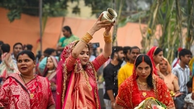A woman performs Chhath Puja as she pours water from a traditional kalash in Gurugram on Monday. (Parveen Kumar/Hindustan Times) A woman performs Chhath Puja as she pours water from a traditional kalash in Gurugram on Monday. (Parveen Kumar/Hindustan Times)