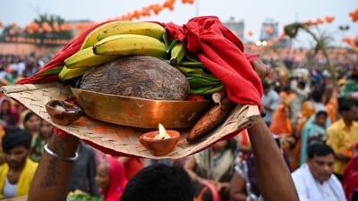 A person carries the Chhath Puja essentials including bananas, a coconut, and a diya, on his head in Gurugram on Monday. (Parveen Kumar/Hindustan Times) A person carries the Chhath Puja essentials including bananas, a coconut, and a diya, on his head in Gurugram on Monday. (Parveen Kumar/Hindustan Times)