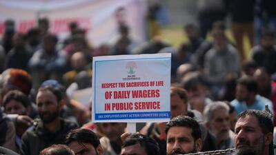 Government employees holding a placard during a protest demanding the regularisation of contractual jobs and a salary hike on Monday. (AP Photo) Government employees holding a placard during a protest demanding the regularisation of contractual jobs and a salary hike on Monday. (AP Photo)
